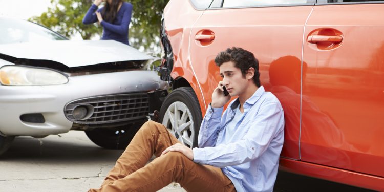 Teenage Driver Making Phone Call After Traffic Accident Sitting Next To Crash.